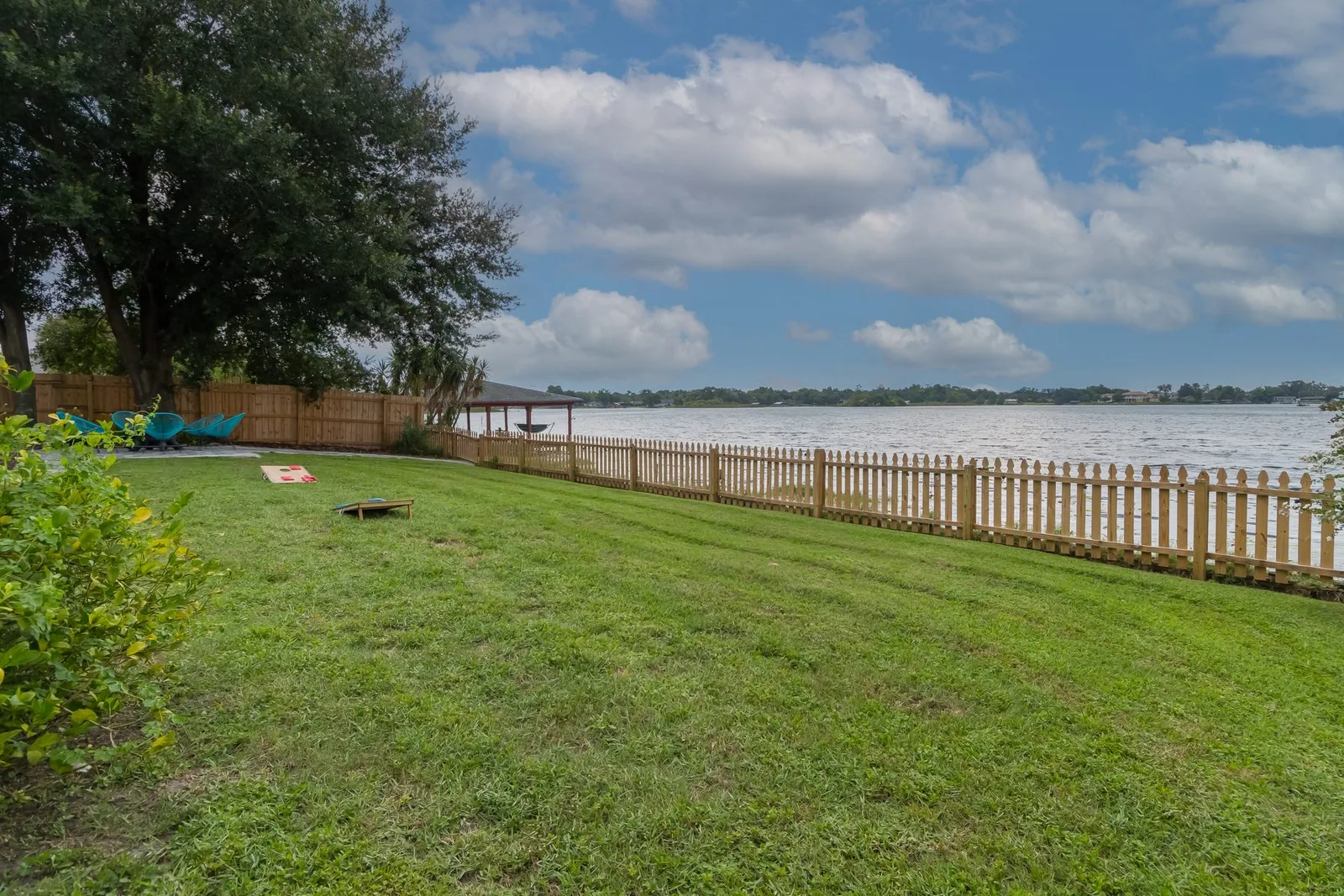 Fenced backyard with a lake view at an Avenir-operated Florida rental property